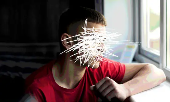 A photograph of a boy gazing out of the window with his face etched out