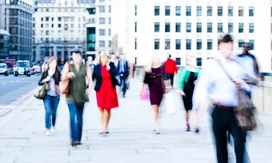 A blurred image of commuters walking in a city.