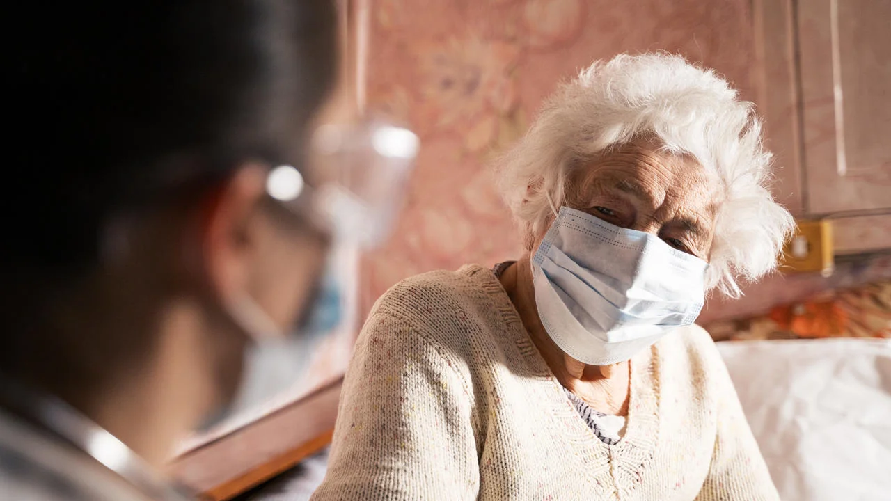 An elderly lady wearing a face mask