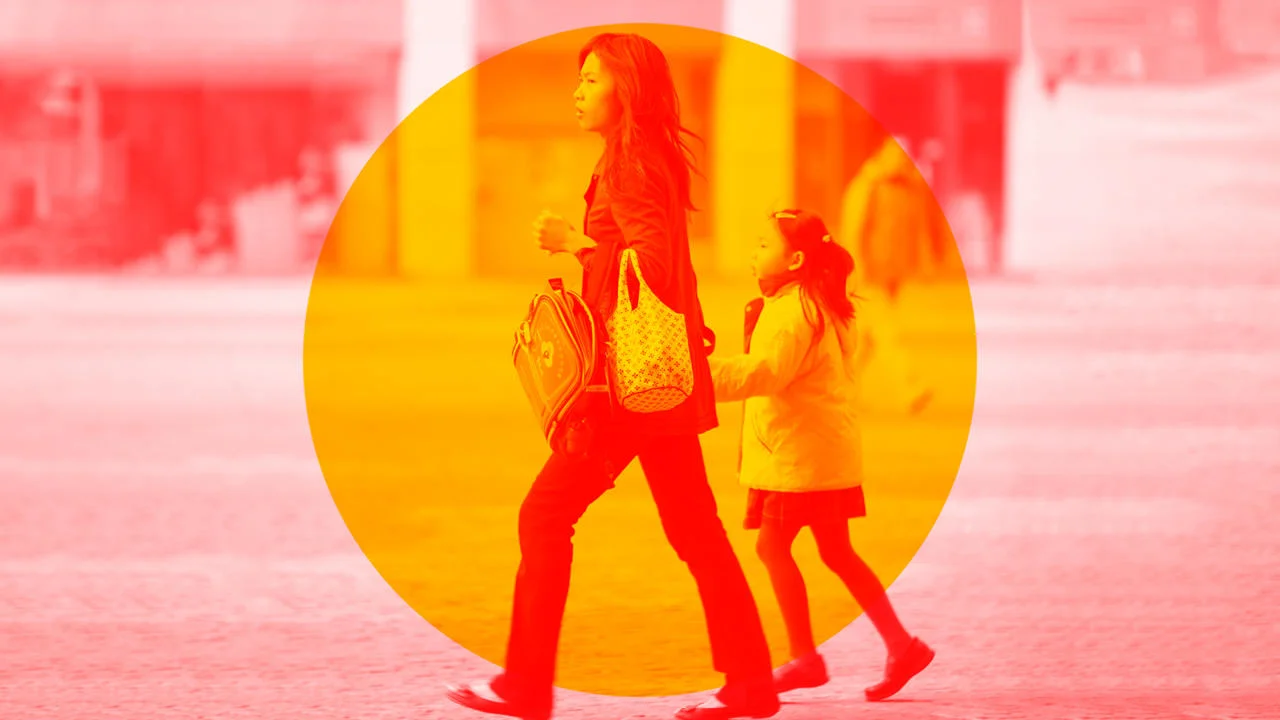 A woman holding a child's hand