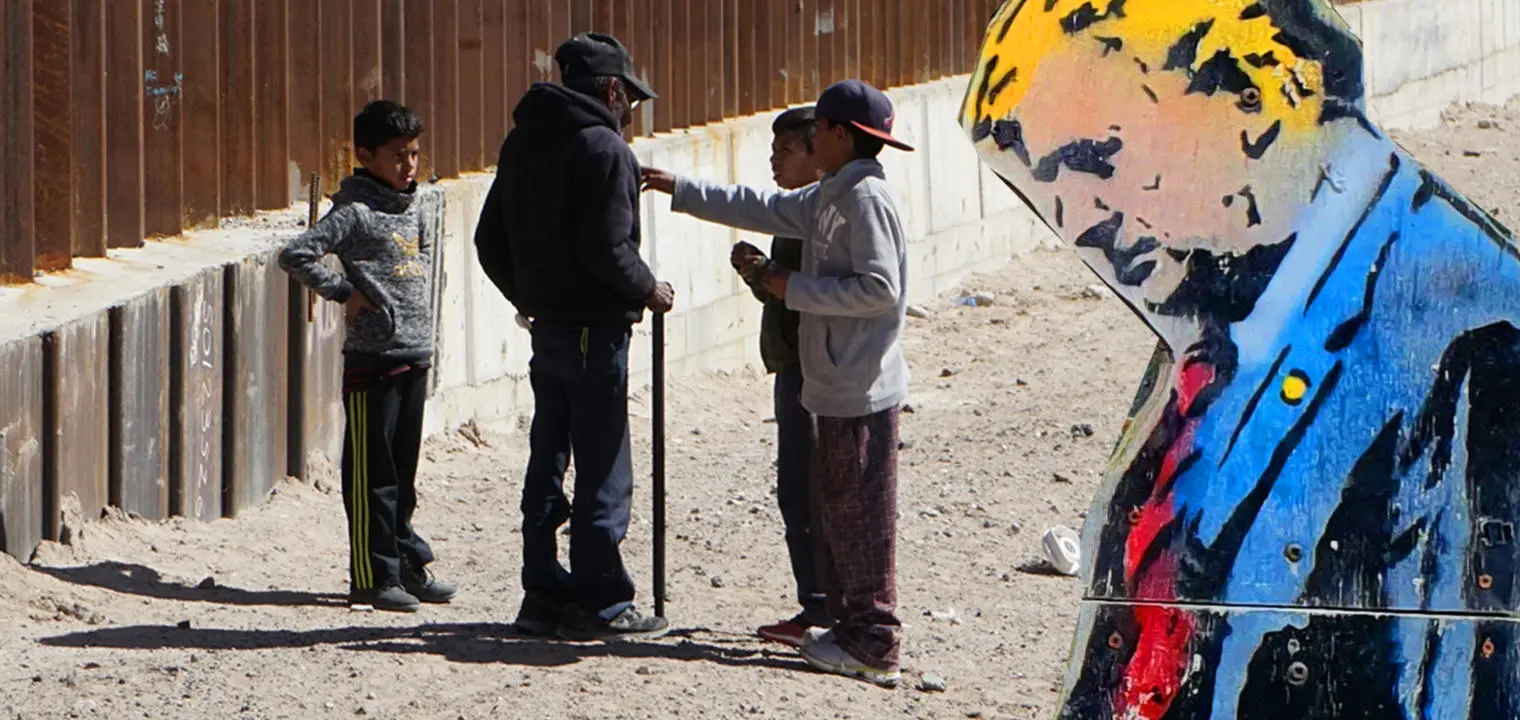 Trump and migrants by a wall