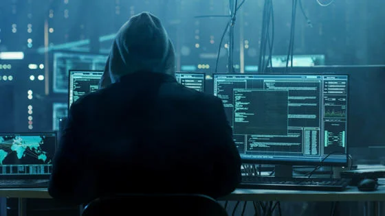 man sitting in front of computer screens