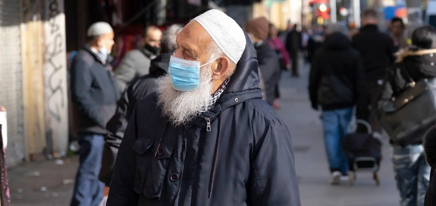A man in a high street wearing a face mask