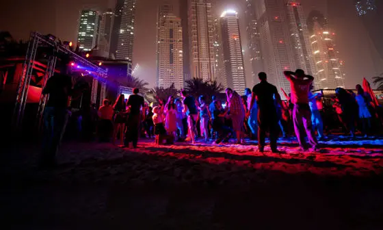People dancing at a nightclub under Dubai skyline
