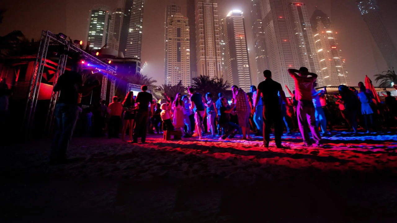 People dancing at a nightclub under Dubai skyline