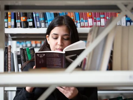 A student reading a book in the Library