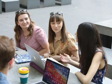 Student group sitting at a cafe with laptops