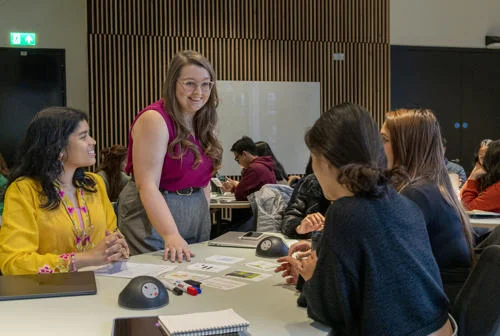 An LSE100 teacher with students in a classroom