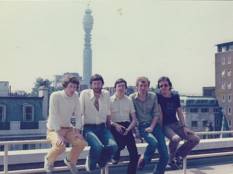 Peter and his friends sit together on a roof with a view of the BT Tower in the background during the 1970s
