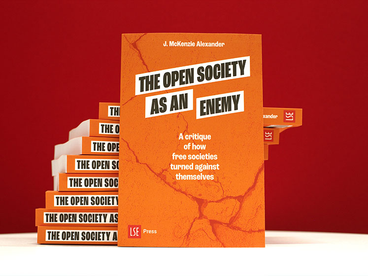 The Open Society as an Enemy promotional images with one copy of the book standing up and the others behind stacked up on top of each other.