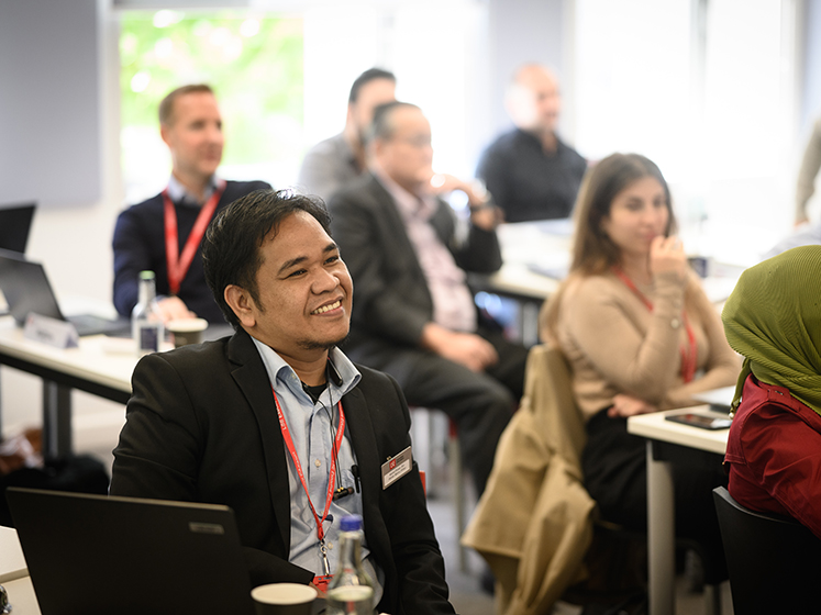 Students enjoying a course, with one man smiling at the front.