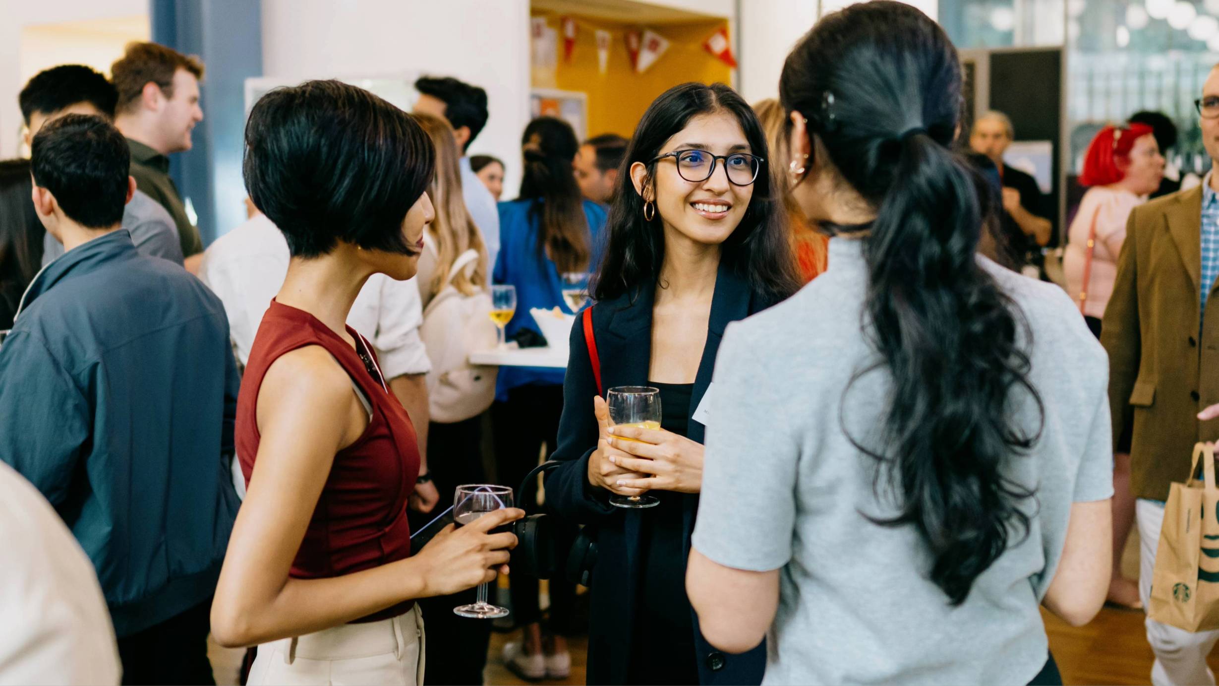 Three women talking at a networking event
