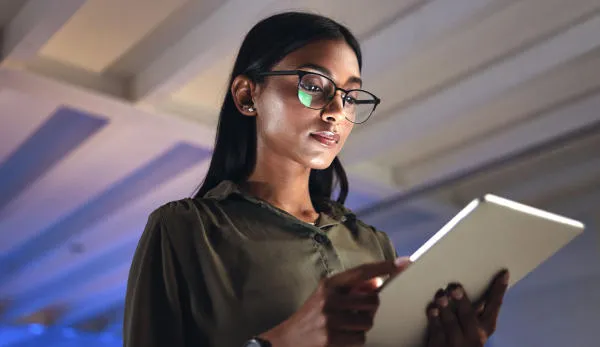 Young business woman looking at a tablet AI Law, Policy and Governance