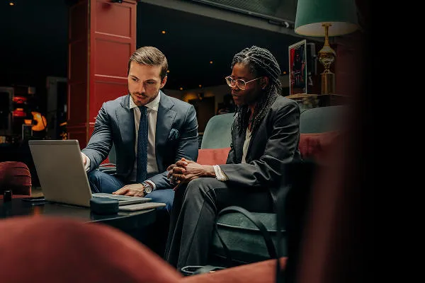 Two people sat on a sofa pointing at a laptop Public Policy Strategy: From Design to Evaluation Programme