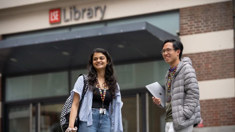 Two people stood outside LSE Library smiling