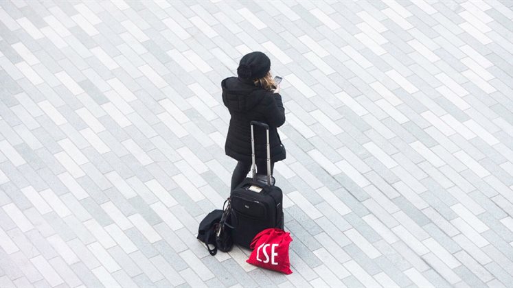 A person stood in a square using their phone