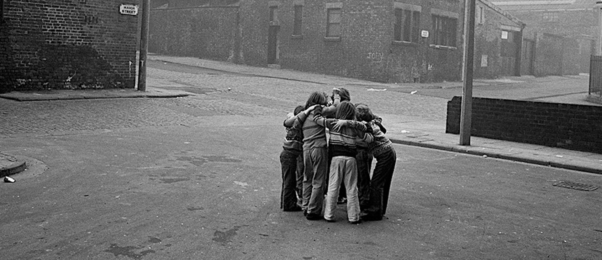 A group of children huddled together in a street