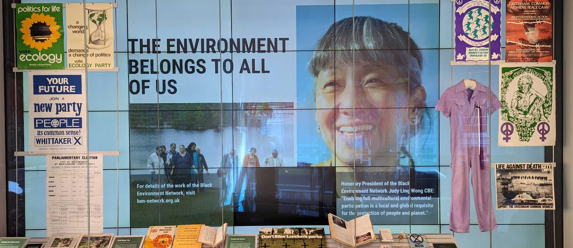 The exhibition video wall including a smiling Judy Ling Wong OBE