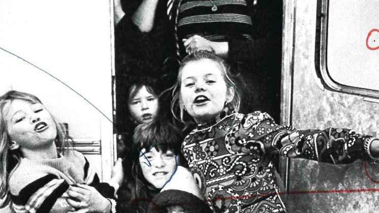 A group of children at the door of a caravan.