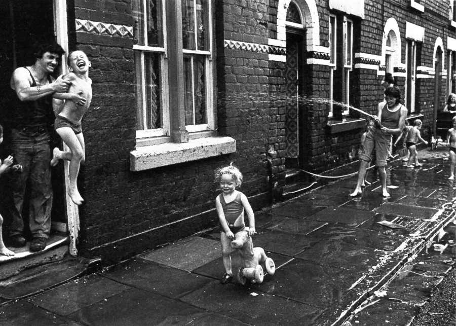 people on a street spraying water