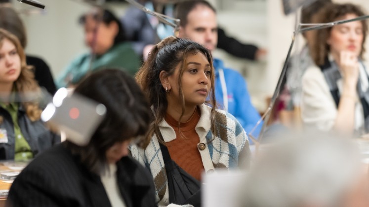 A woman in focus within a larger audience at an LSE Library event