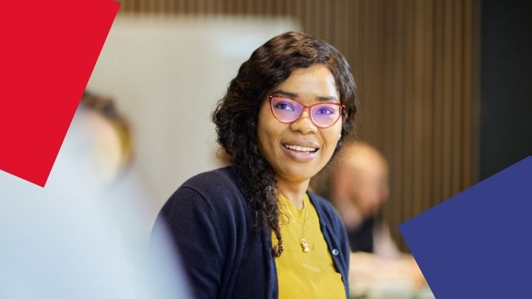 Female student smiling to camera in a bright yellow top.