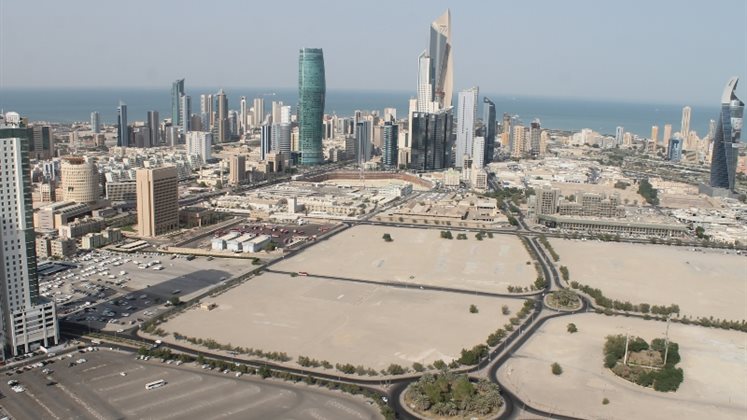 Birds-eye view of Kuwait city, with space in the foreground and skyscrapers in the background.