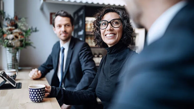 Colleagues talking and smiling in a meeting Leadership and Change