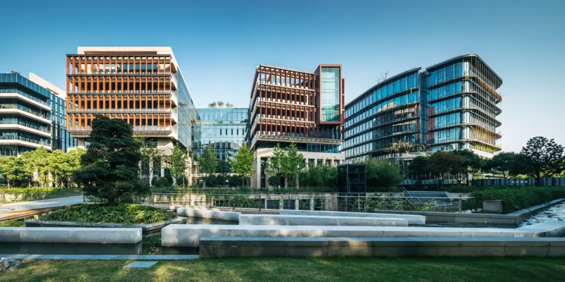 Three buildings with lake and trees in front  Sustainability: Environment, Economy and Society