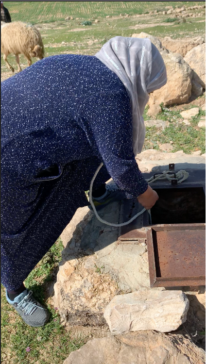 Woman draws water form well in Jabal Bani Hamida