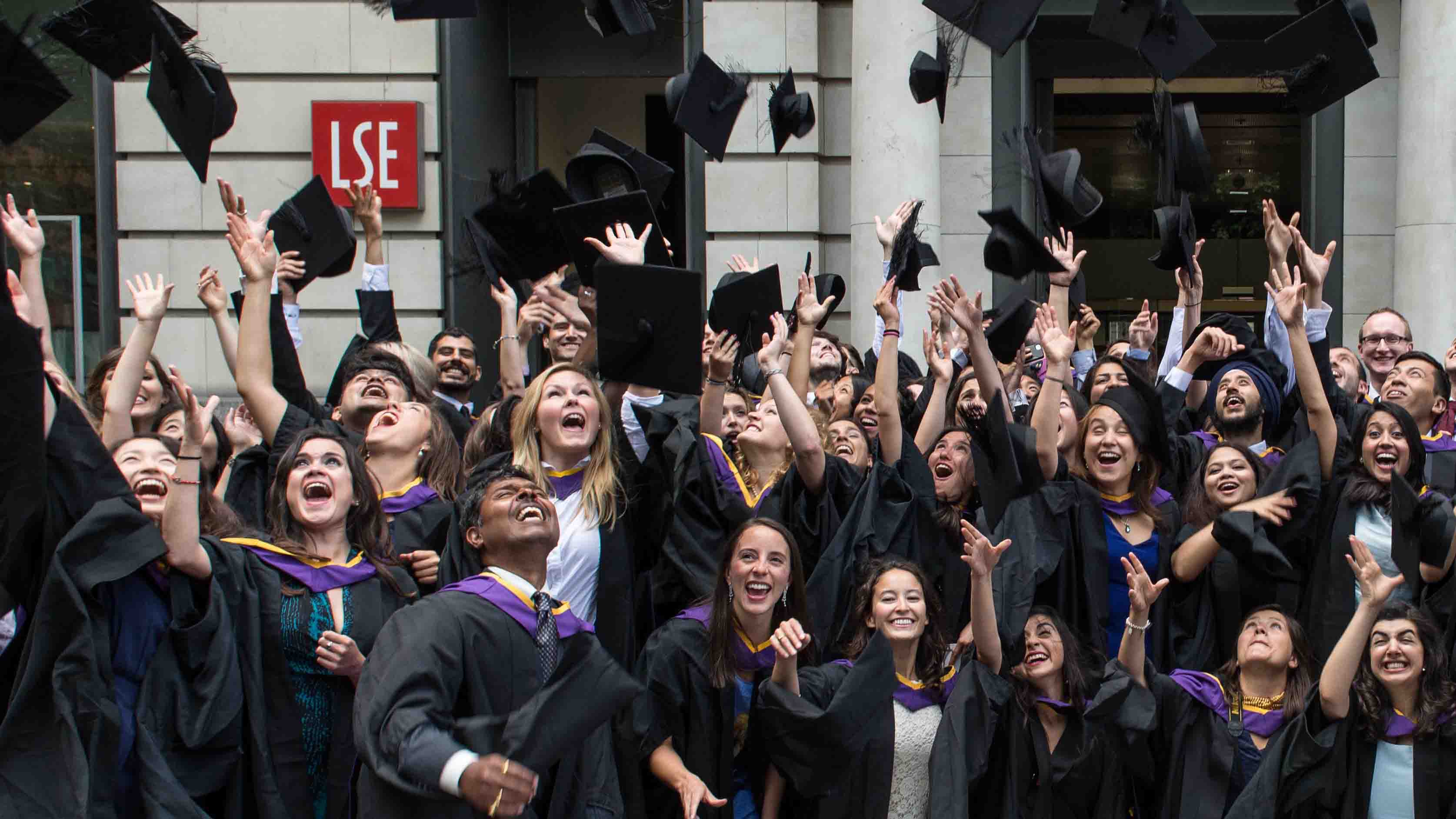 MPA graduates throwing their mortarboards in the air