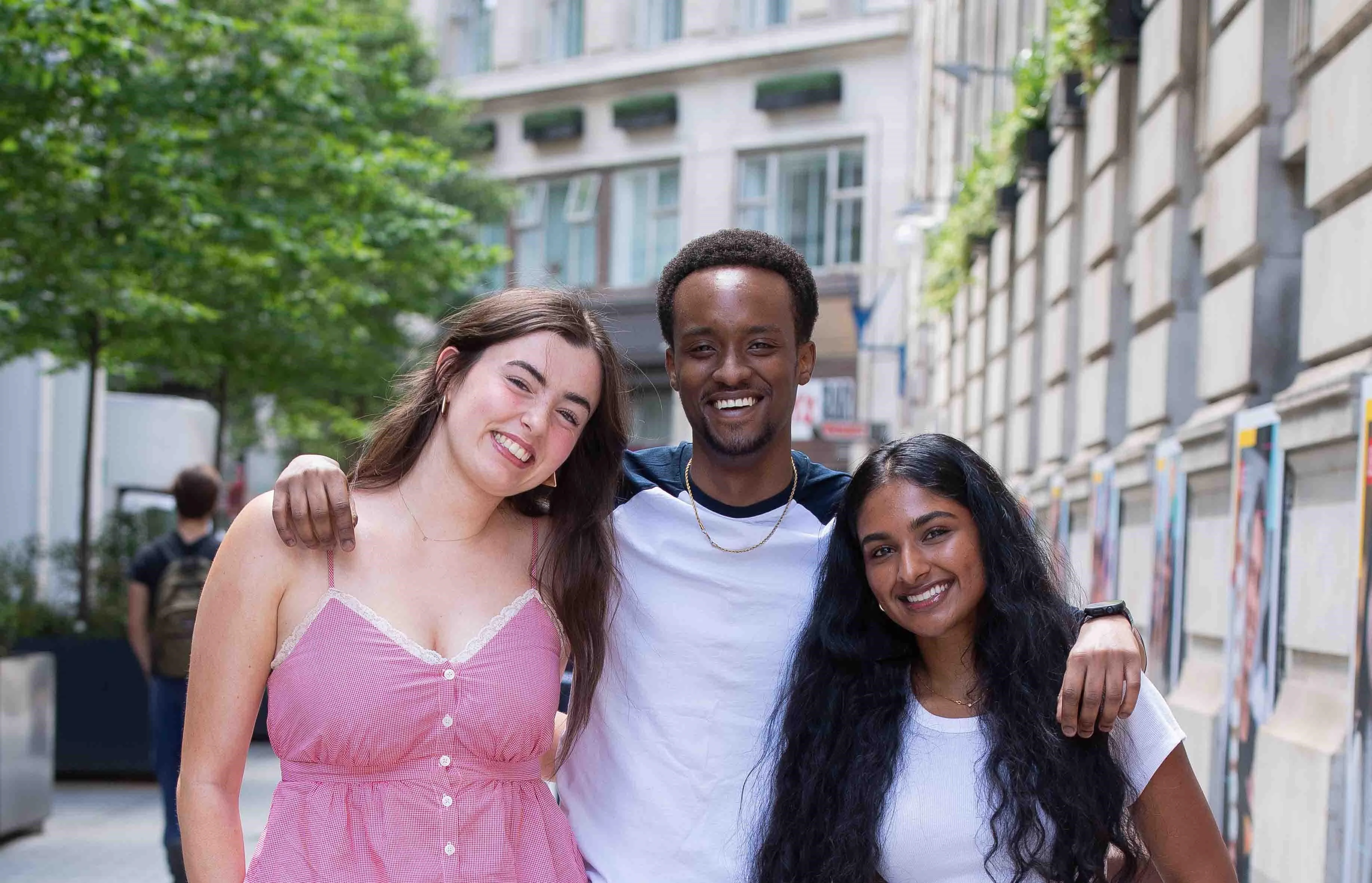 Three students smiling at camera on Houghton Street