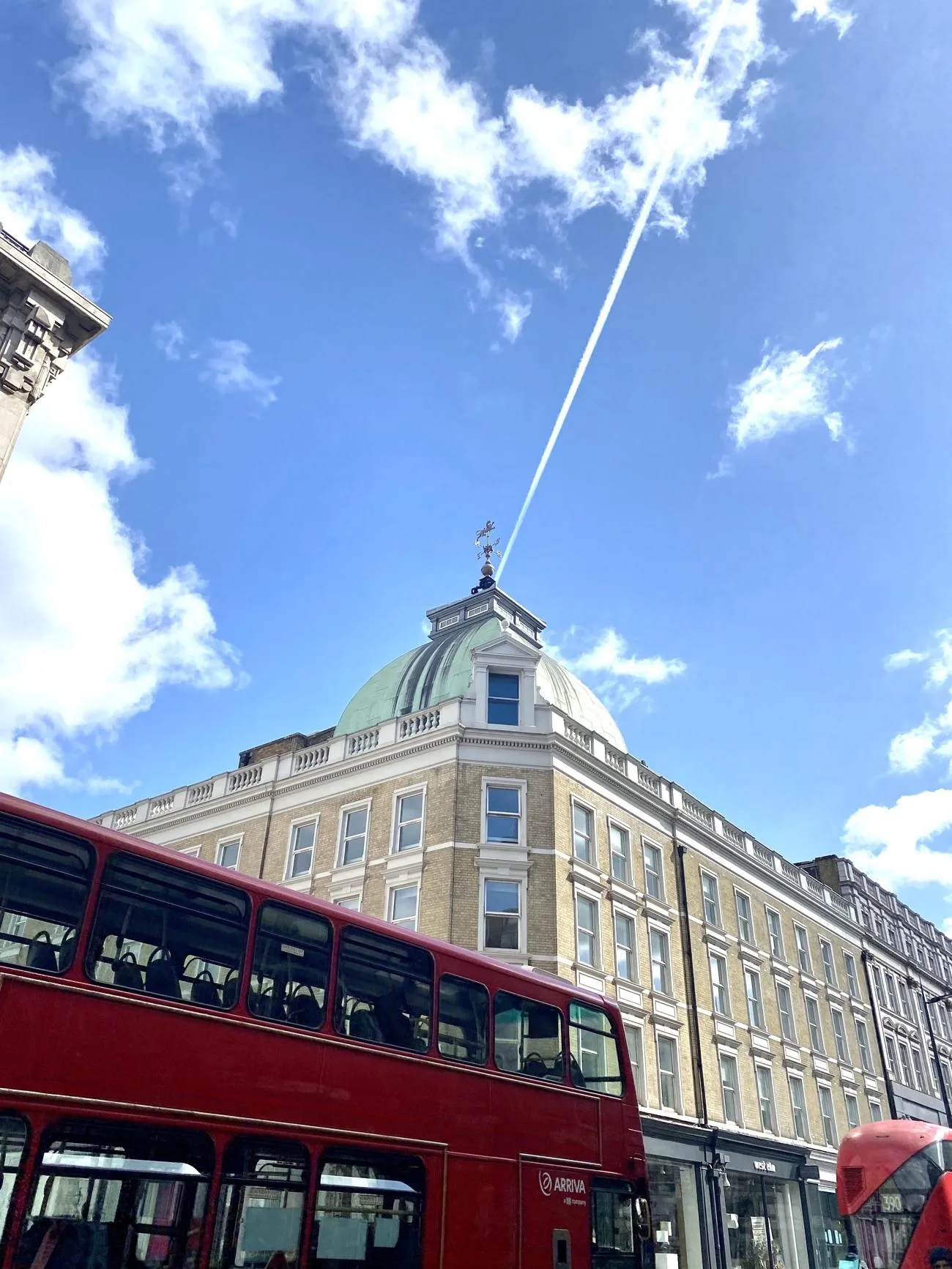 Red bus with blue sky and clouds background