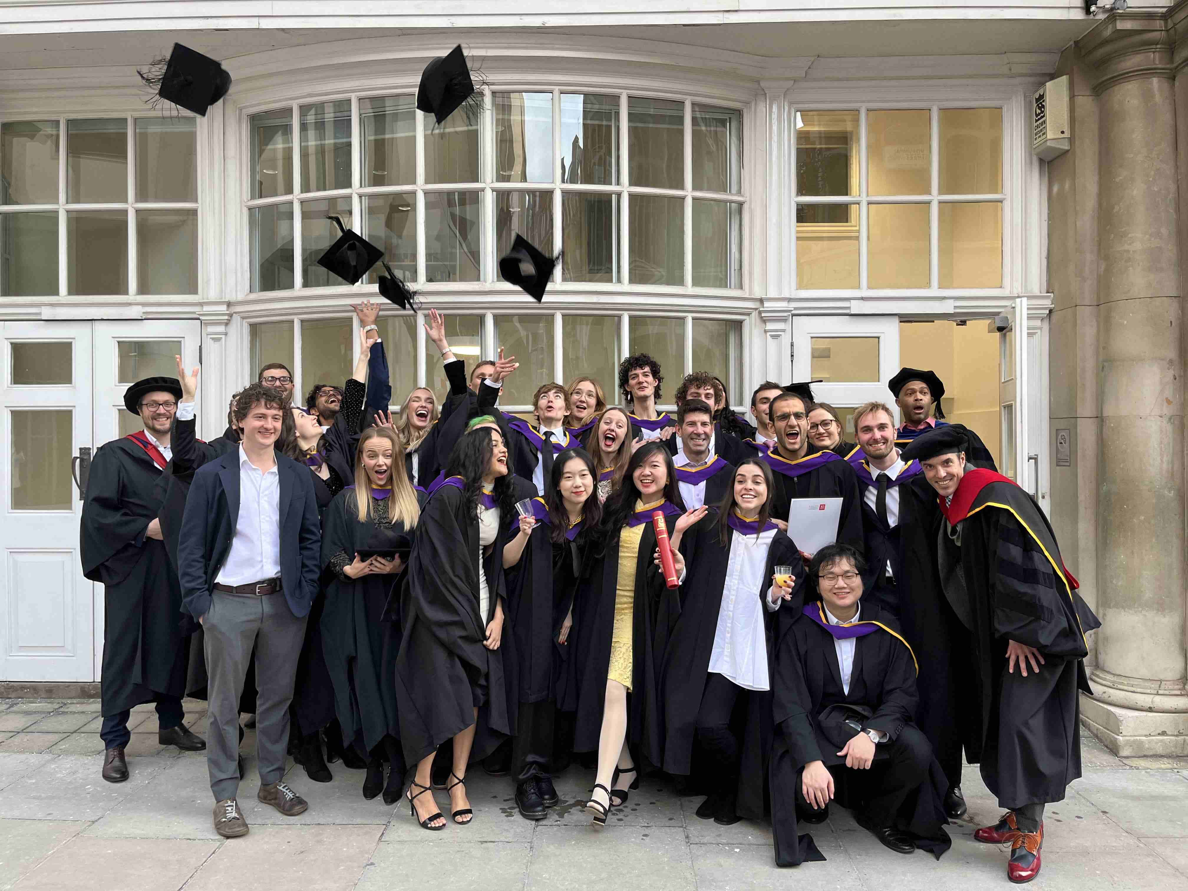 LSE students graduating, throwing graduation caps in the air